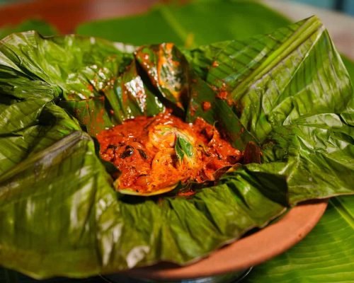 Chemmeen kizhi wrapped in banana leaf served at Spice Aromas restaurant